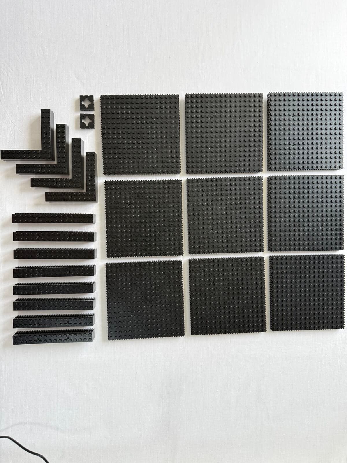 The kit's nine studded baseplates laid out in their grid with the snap-together frame parts